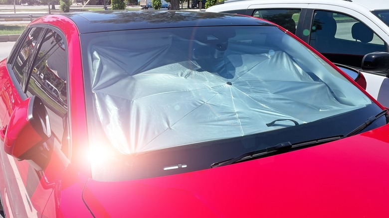 Red car with a sunshade in the windshield