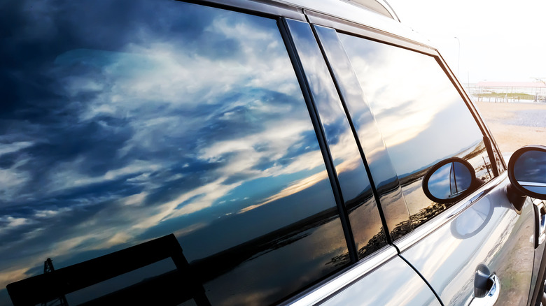 Car window reflecting sky