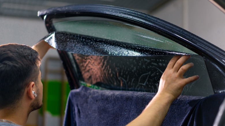 Person installing car tint