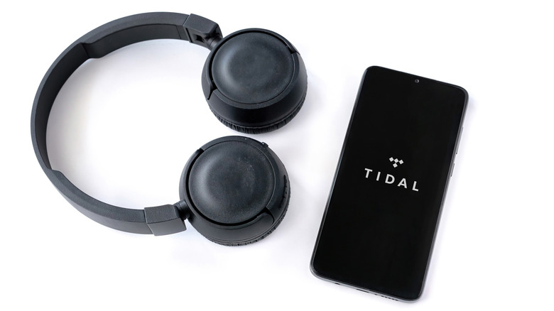 Tidal app on a smarpthone with headphones on the side