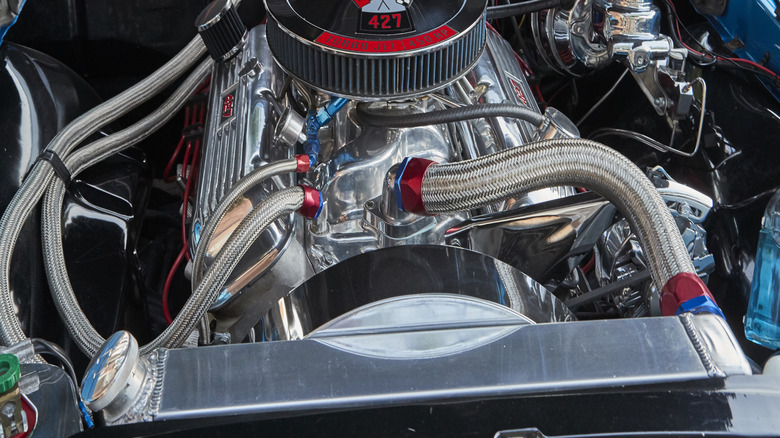 A Chevy 427 big block engine, all chromed out in a blue Impala's engine bay
