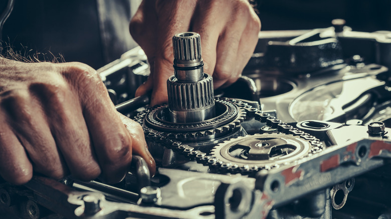 hands working on a transmission gearbox