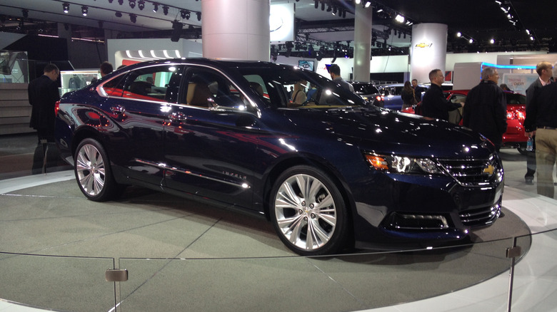 The 2014 Chevrolet Impala in dark blue at an auto show, front 3/4 view