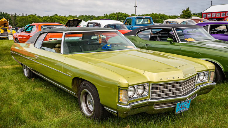 An early 1970s Chevrolet Impala in lime green, vinyl roof, Sport Coupe, front 3/4 view