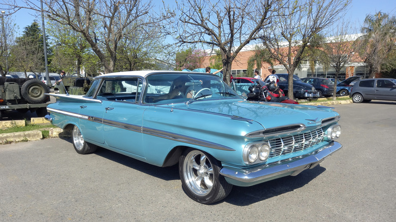 A two-tone teal blue and white 1959 Chevy Impala sedan