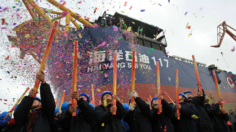 Workers blast confetti to commemorate the launch of a freighter.