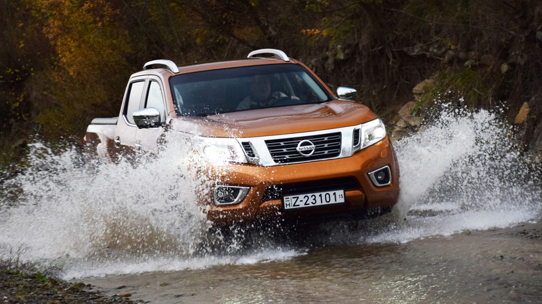 orange Nissan driving through water