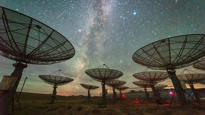 satellite dishes pointing at starry sky