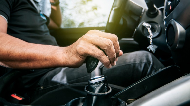 hand grabbing gear lever