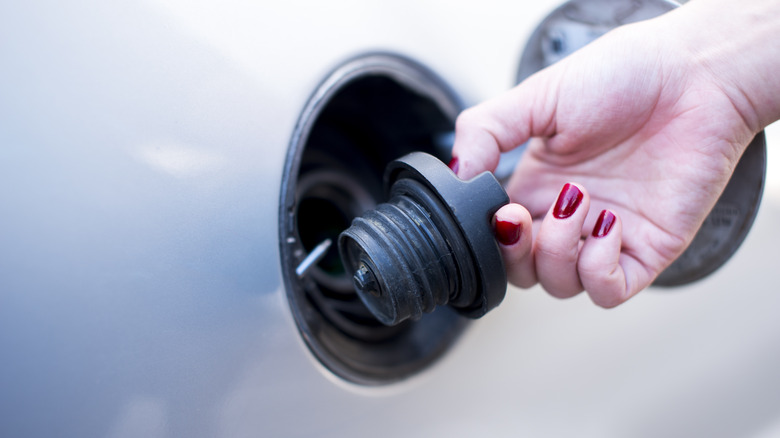 Hand holding gas cap