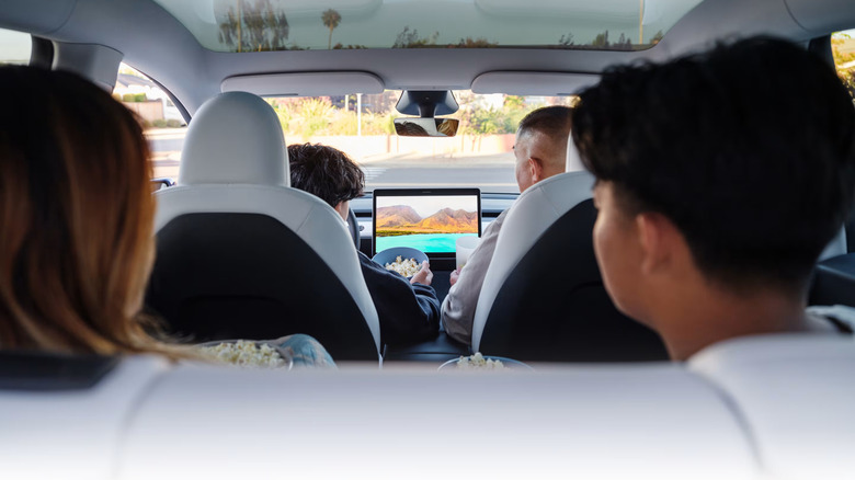 four people sitting in a Tesla Model Y