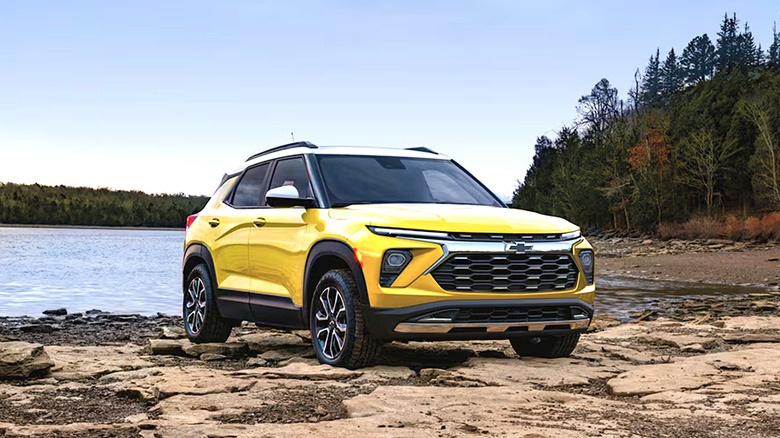 A yellow Chevy Trailblazer in front of a lake