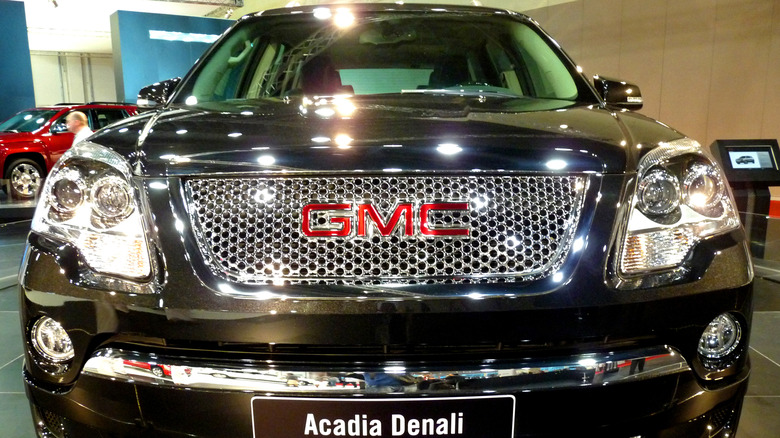 A black 2010 GMC Acadia Denali on display in a showroom.