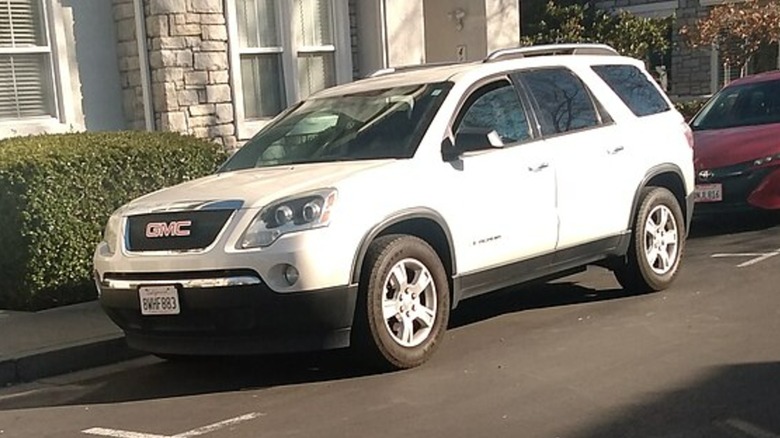 A white 2007 GMC Acadia parked on a street.