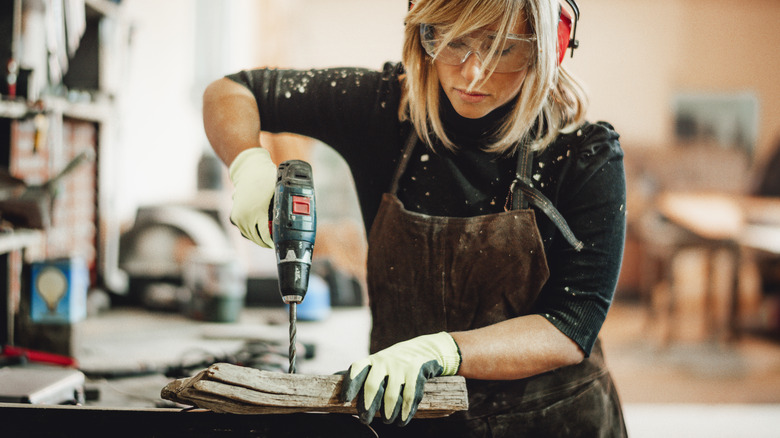 person using power drill on wood