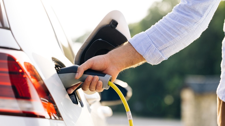 person charging electric car