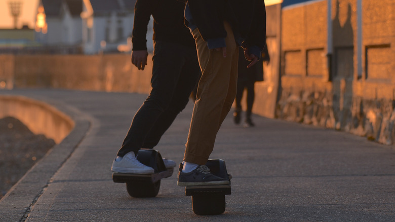 Two people using Onewheel skateboards