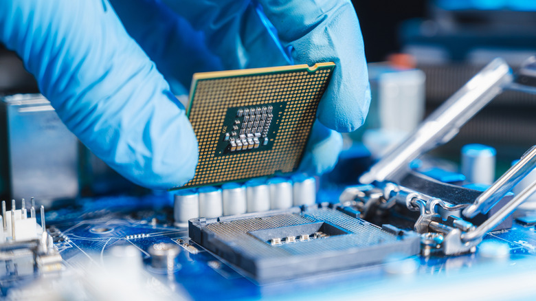 Gloved hand installing CPU on motherboard