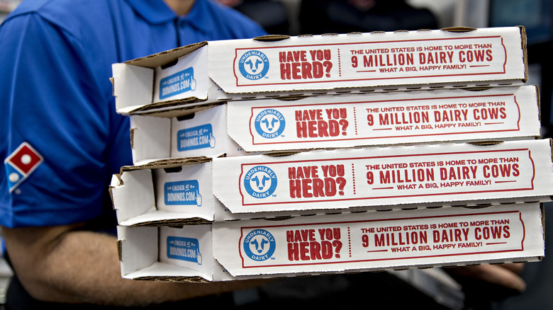 Domino's employee holding pizza boxes