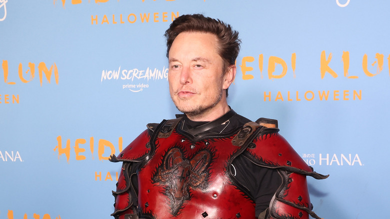 Elon Musk posing in a Halloween costume at an event.