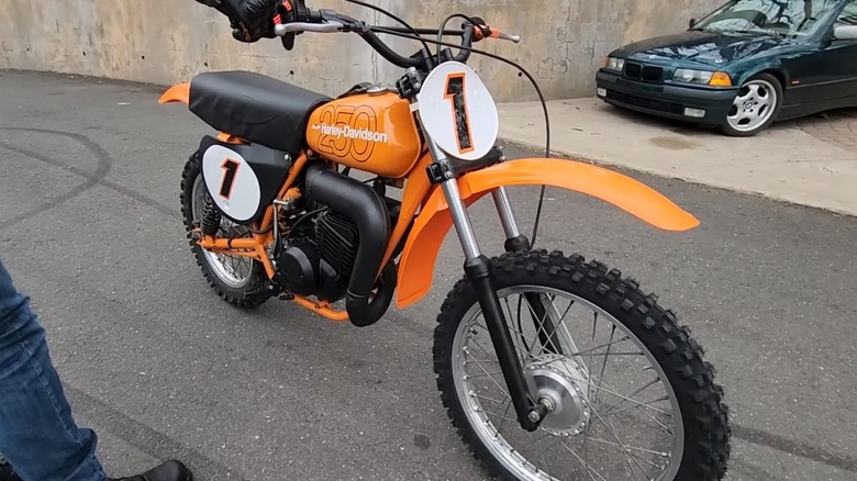 Man holding up a Harley-Davidson MX250