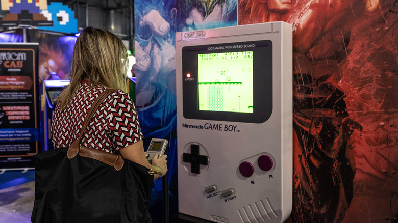 woman playing a Game Boy