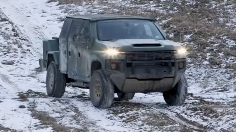 The Next Generation Tactical Vehicle-Hybrid (NGTV-H) driving on an unpaved road in the snow