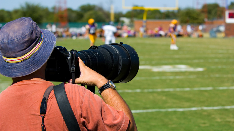 man shooting football game with super telephoto