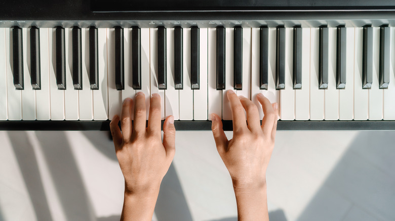 two hands playing piano