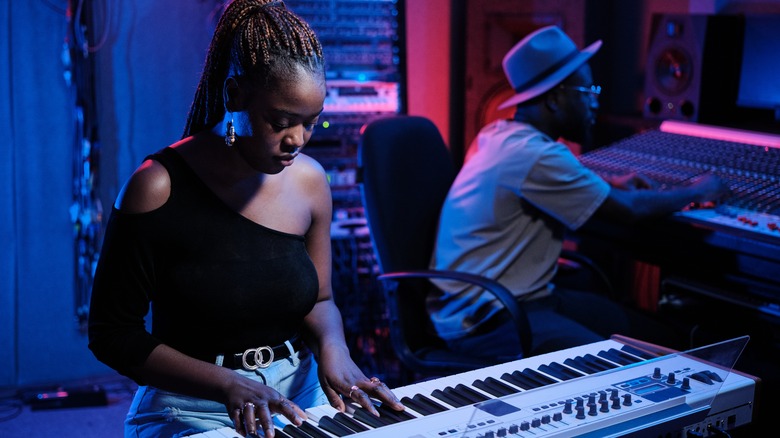 woman playing keyboard in music studio