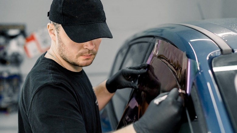 Man putting tint on window