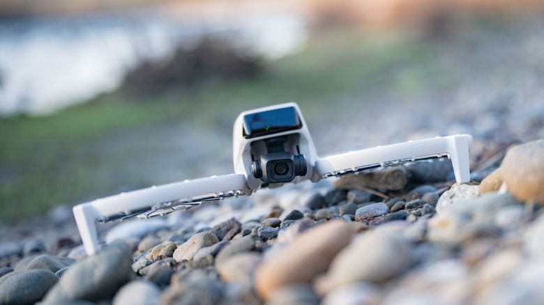 DJI Flip on a rocky beach by a river.