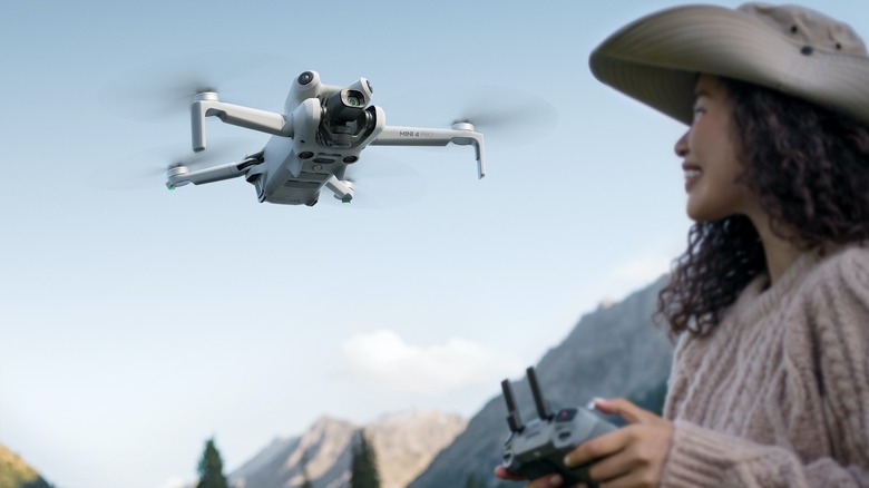 A woman using a DJI Mini Pro 4