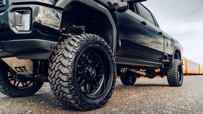 Big tires on truck parked on dirt