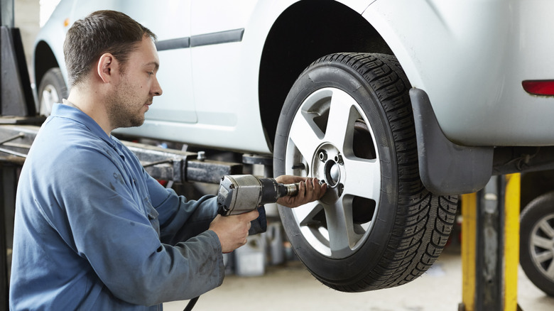 Man installing tires on car