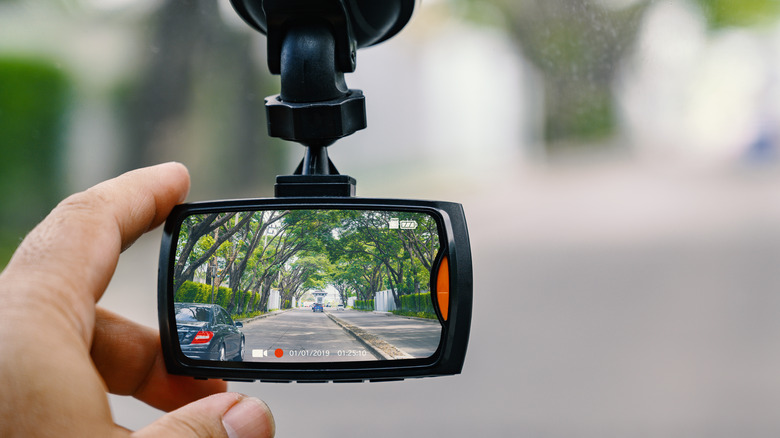 Person adjusting dash cam