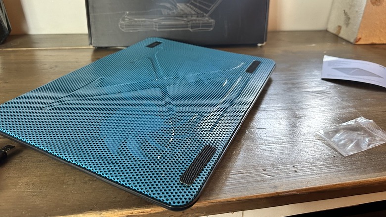 Close up of a laptop cooler sitting on a wooden table