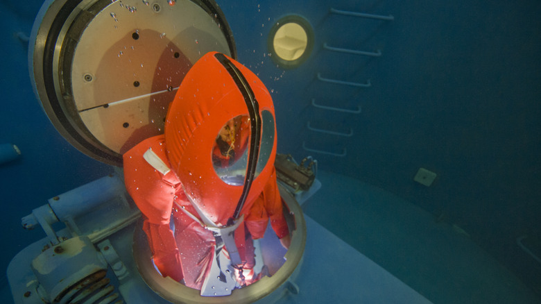 A sailor wearing an orange SEIE suit underwater