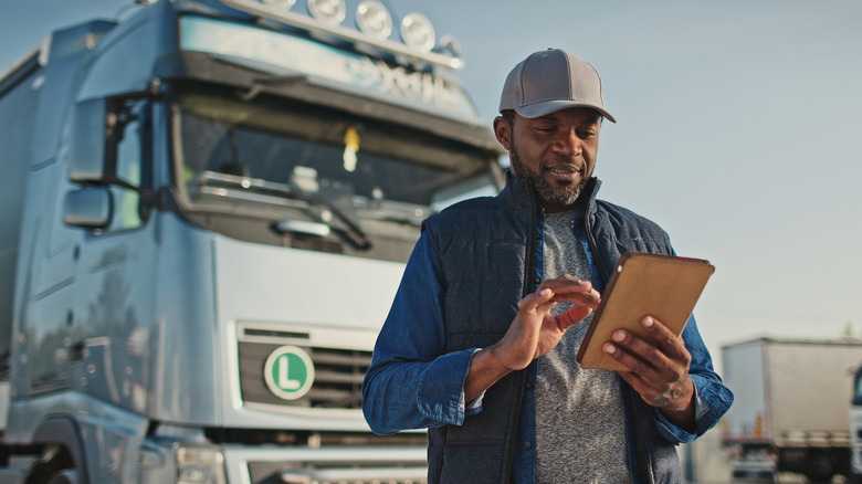 Man checking tablet outside truck