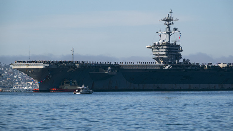 The U.S. Navy Nimitz-class aircraft carrier USS Abraham Lincoln (CVN 72) is guided by tugboats in San Diego Bay.