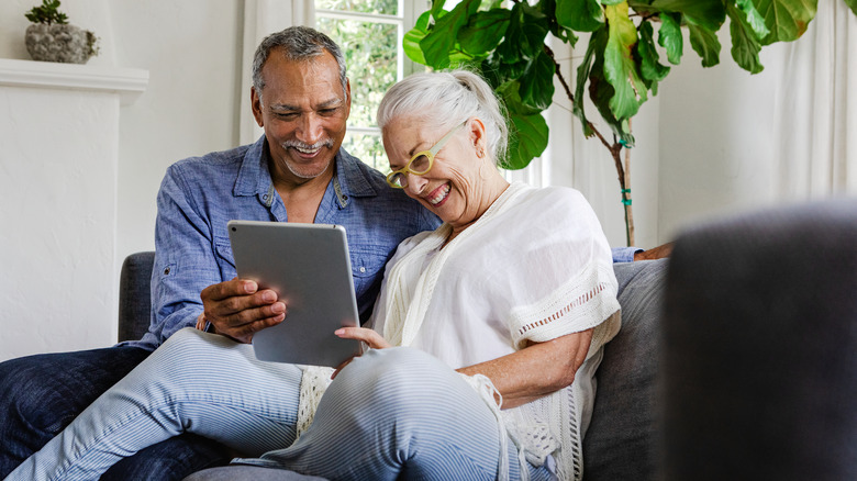 Couple watching tablet laughing