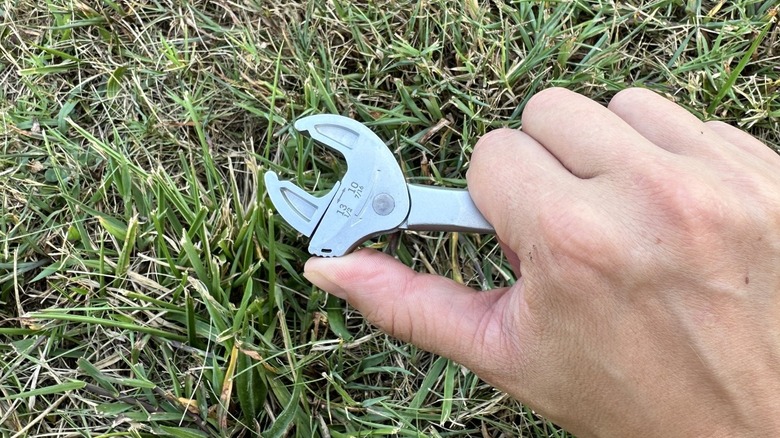 Adjusting a self setting wrench with a grassy background