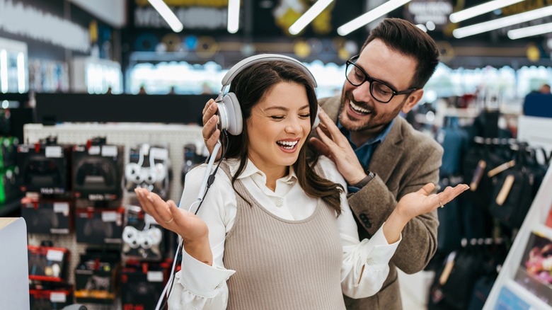 couple buying headphones at store
