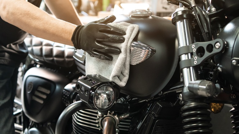 Person cleaning a naked motorcycle