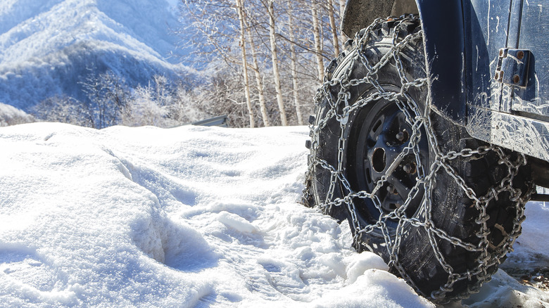 Vehicle with tire chains on wheel in snowy environment