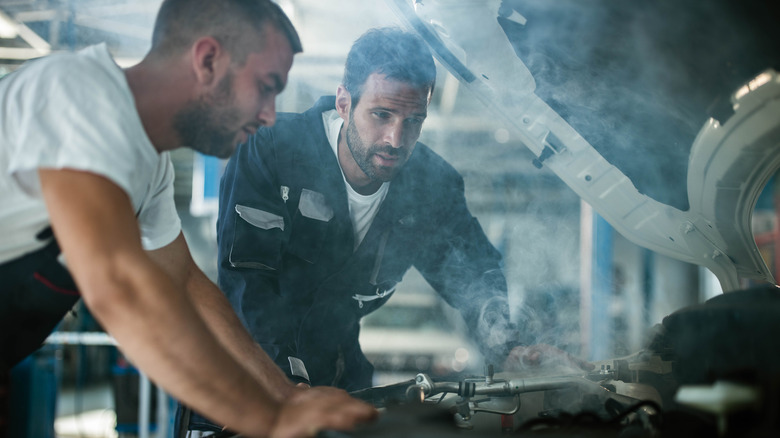 Mechanic looking at smoking engine