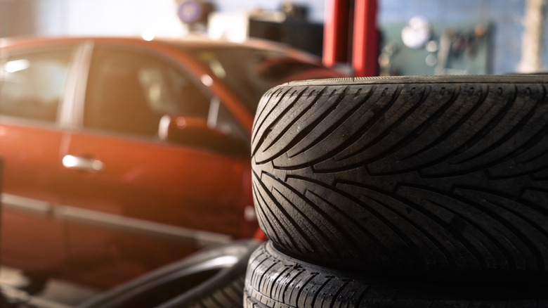 Stack of tires in front of a car