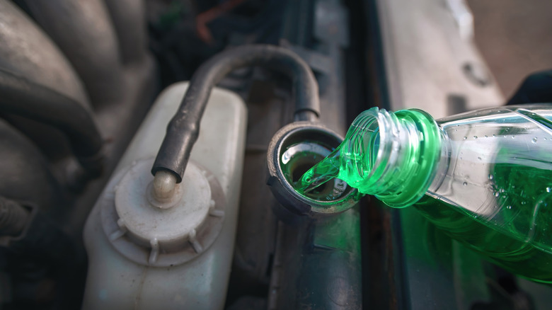 pouring green coolant in car radiator