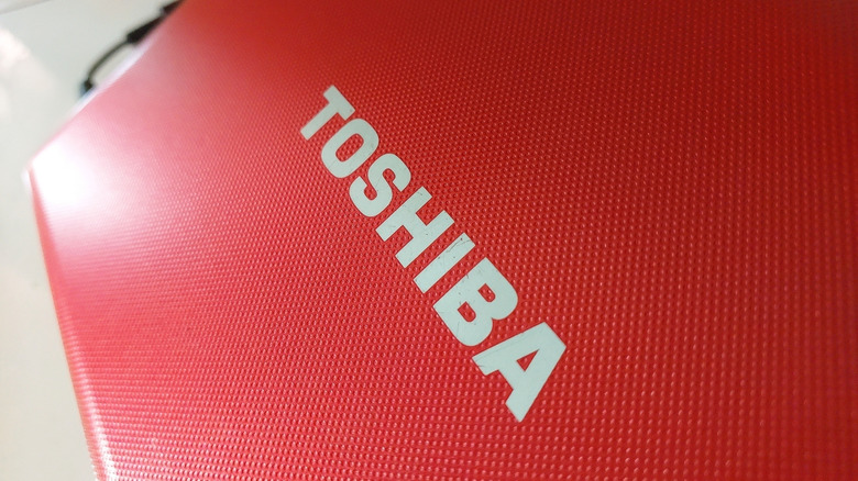 The Toshiba brand on the back of a red laptop