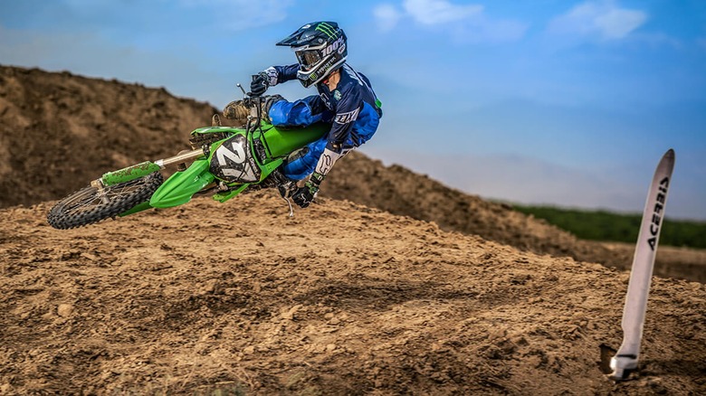 Motocross racer scrubbing a jump on a Kawasaki KX112 